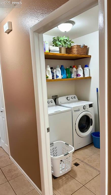 Image 12 of 34: Laundry room with light tile patterned floors, independent washer and dryer