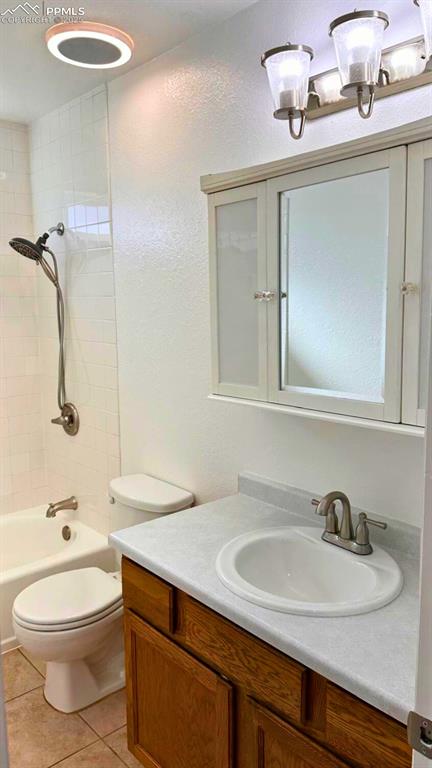 Image 15 of 34: Bathroom with vanity, tub / shower combination, light tile patterned floori