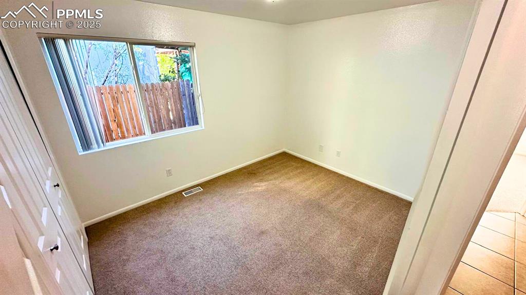 Image 19 of 34: Carpeted empty room with baseboards. un-staged