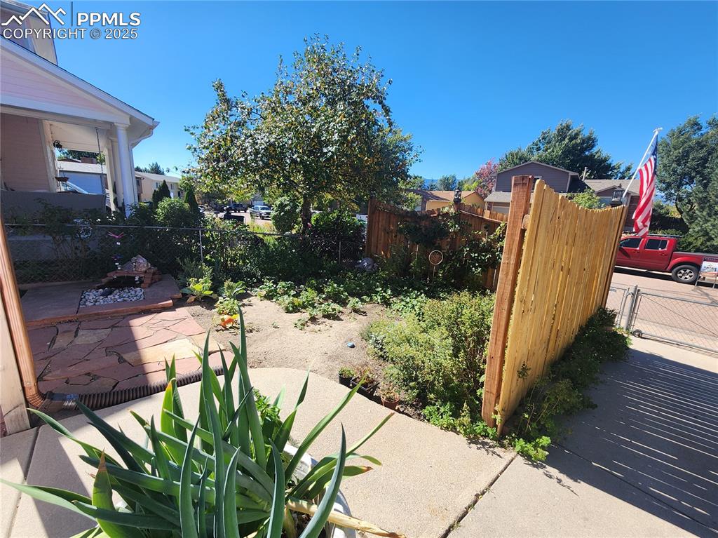 Image 3 of 34: View of yard with a garden, patio area, water feature and a privacy gate