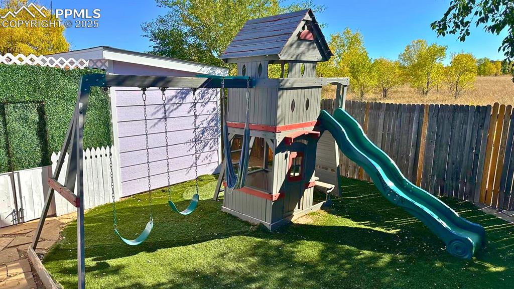Image 30 of 34: View of jungle gym featuring a fenced backyard