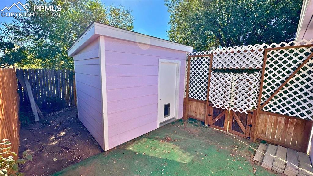 Image 32 of 34: View of shed with a fenced backyard and a gate