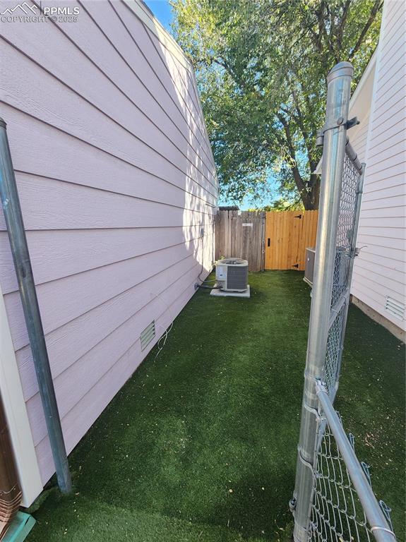 Image 6 of 34: View of side yard with a gate and A/C Compressor