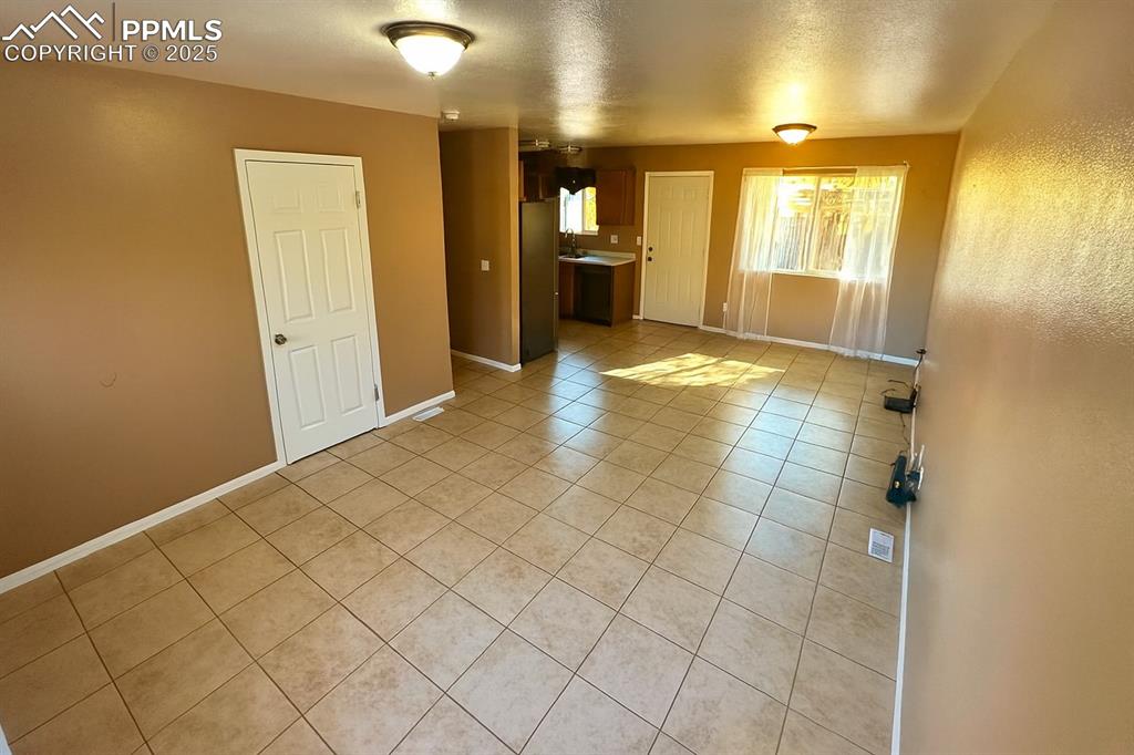 Image 8 of 34: Unfurnished living room featuring light tile patterned floors and a texture