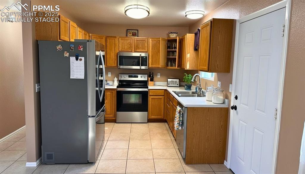 Image 9 of 34: Kitchen featuring appliances with stainless steel finishes, light counterto