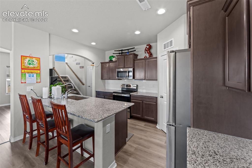 Image 11 of 41: Kitchen featuring wood-finish flooring, recessed lighting, a kitchen island