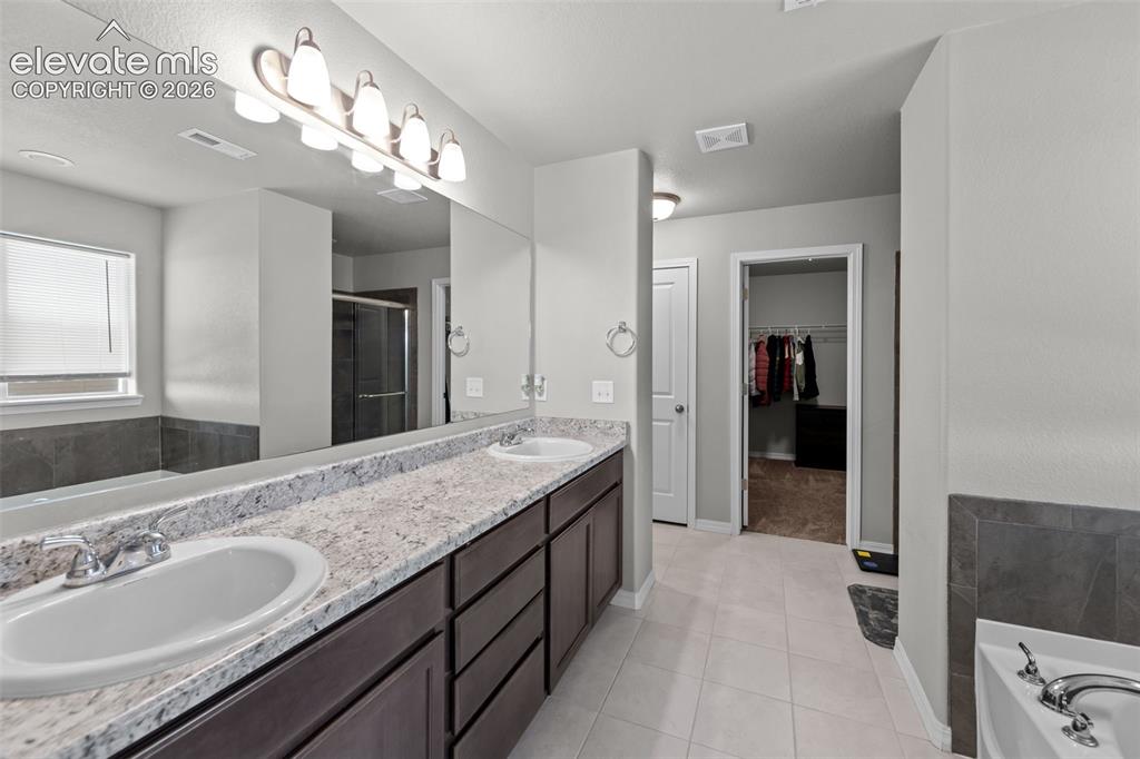 Image 17 of 41: Double vanity with undermount sinks and light-toned countertops