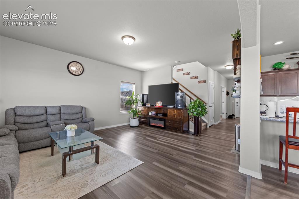 Image 26 of 41: Open-concept living space featuring wood-finish flooring, recessed lighting