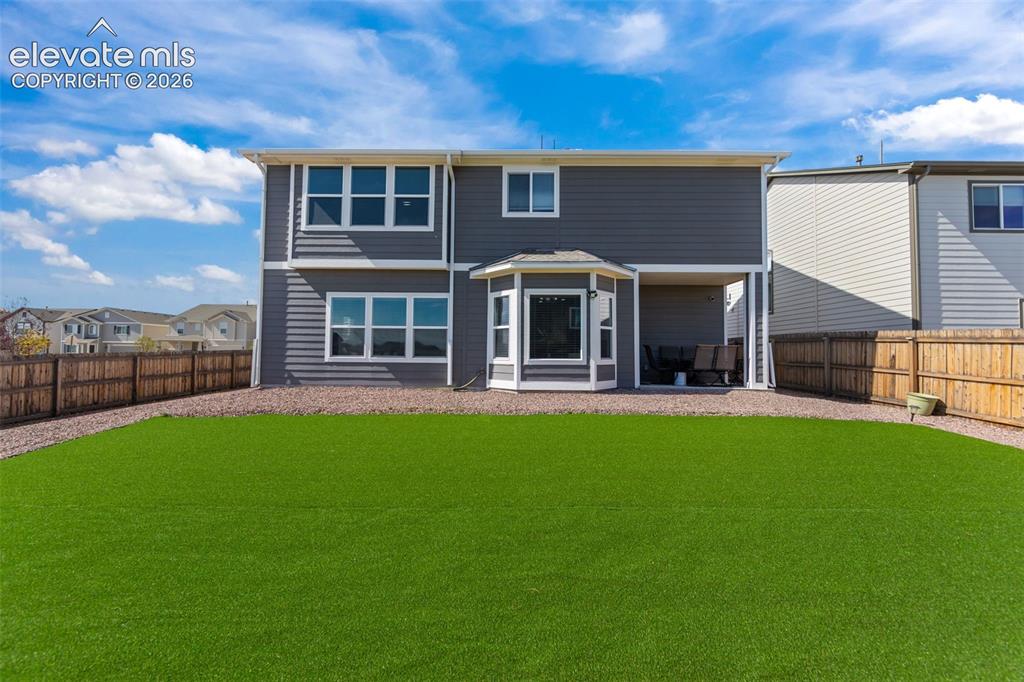 Image 27 of 41: Expansive backyard featuring a green lawn and gravel border