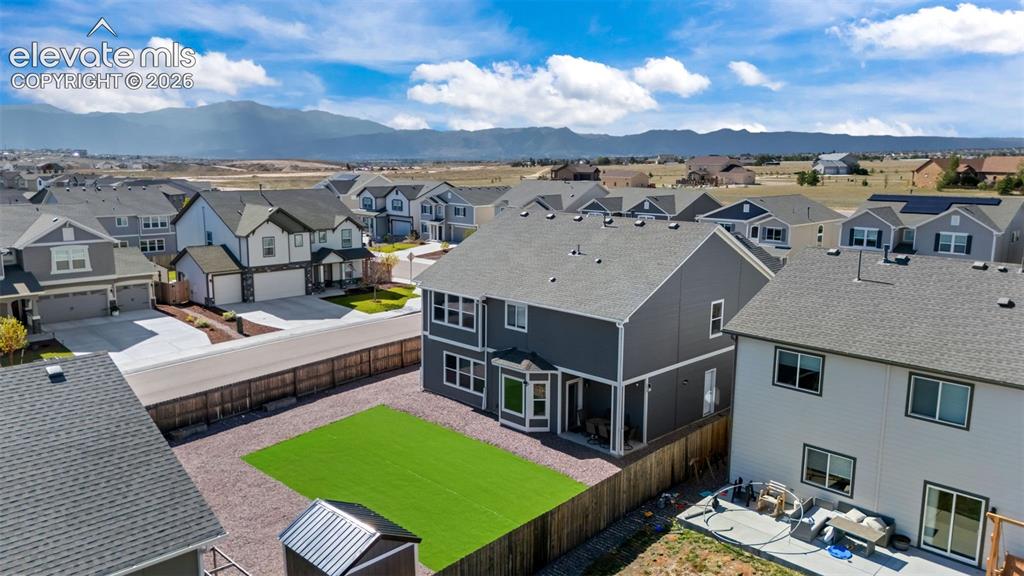 Image 35 of 41: Expansive backyard with artificial turf and gravel landscaping
