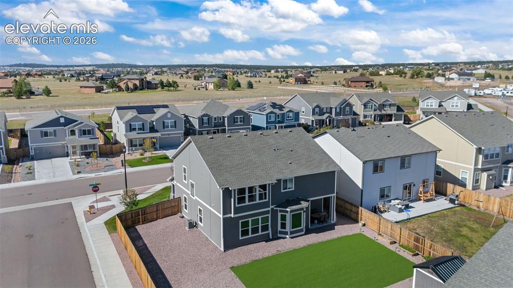 Image 37 of 41: Two-story residence with a gray exterior and a shingled roof, featuring mul