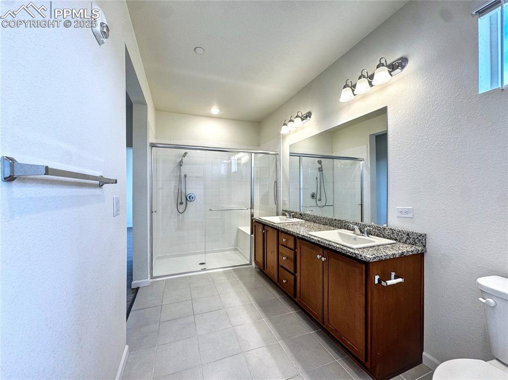 Image 22 of 29: Primary Bathroom with walk in shower, double sinks and stone vanity
