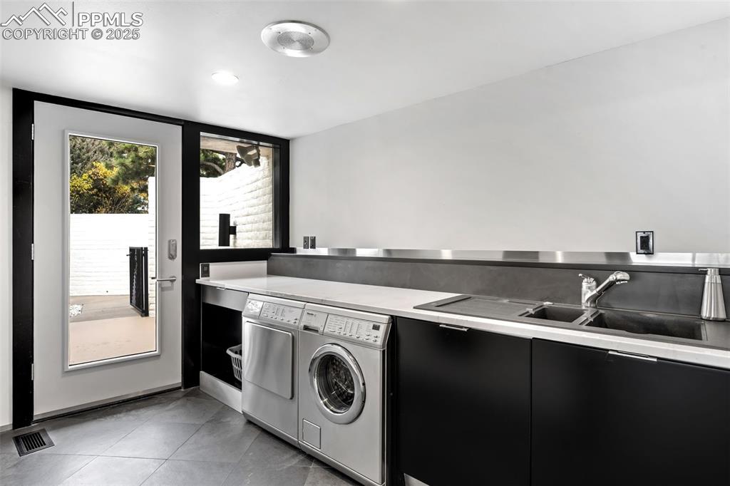 Image 12 of 39: Laundry room with light tile patterned floors and washer and clothes dryer
