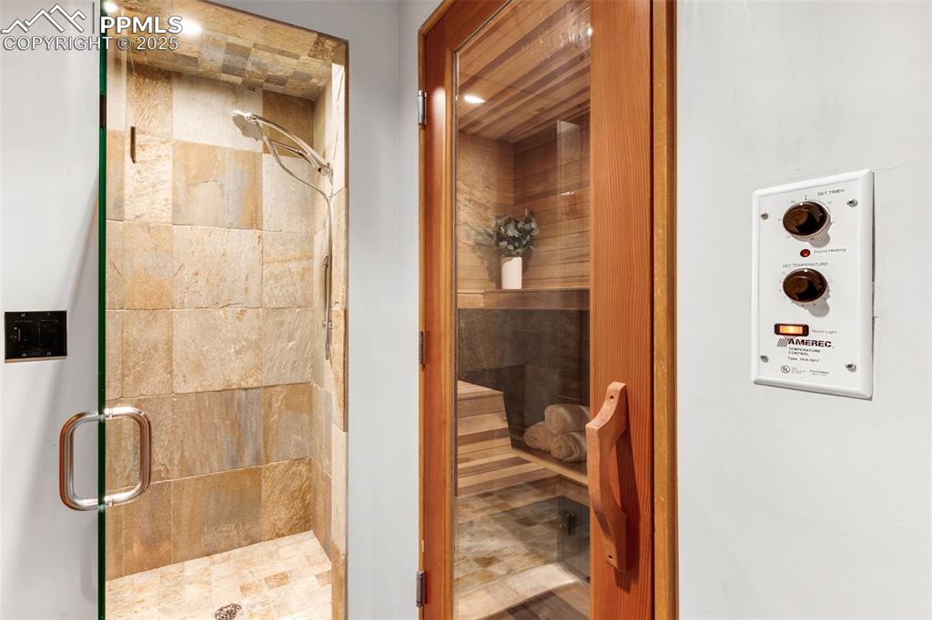 Image 32 of 39: Bathroom featuring a relaxing sauna and a stall shower