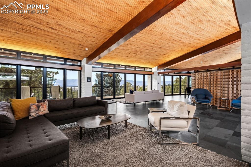 Image 5 of 39: Tiled living room featuring expansive windows and a wooden ceiling with exp