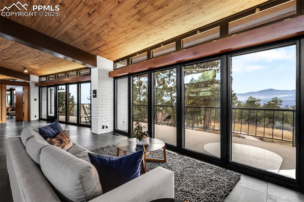Image 6 of 39: Sunroom featuring a mountain view and beam ceiling