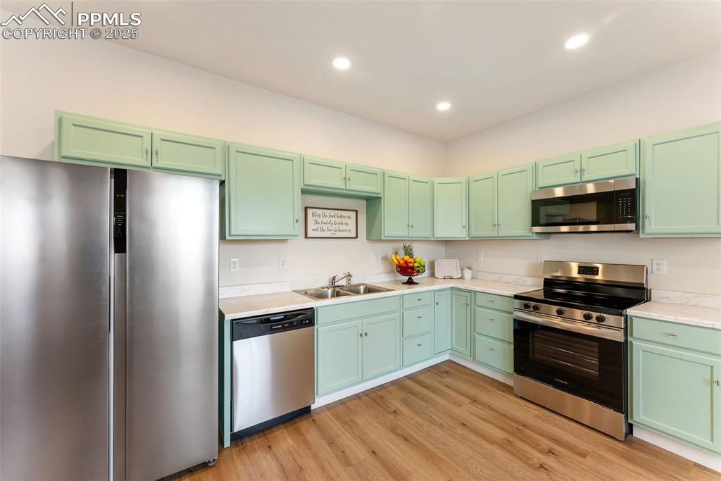 Image 10 of 42: Light but still warm colored cabinets and quartz countertops