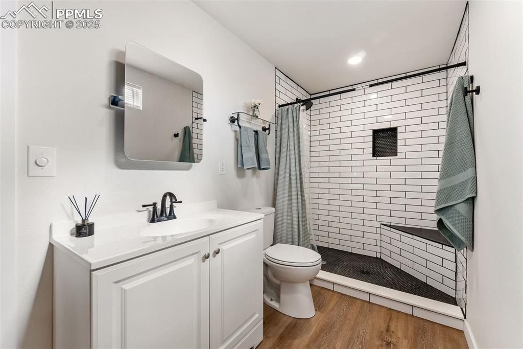 Image 20 of 42: Remodeled 3/4 bath with a walk-in shower with floor to ceiling tile surroun