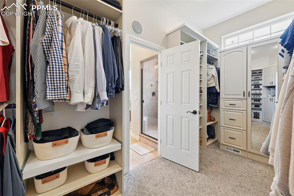 Image 23 of 50: Large custom primary closet connects to laundry room.