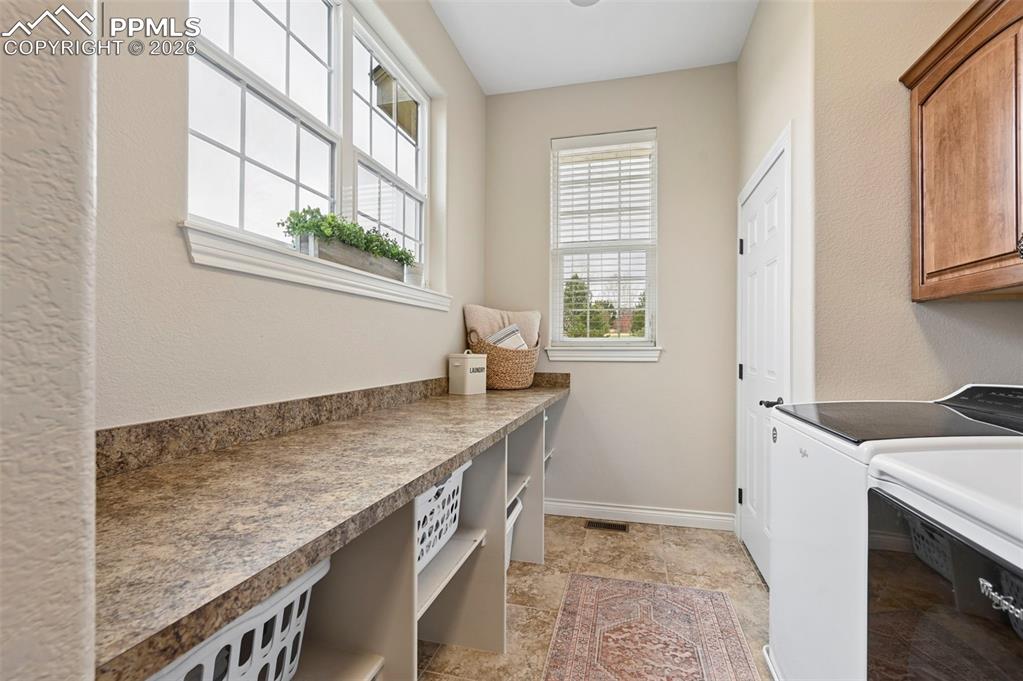 Image 25 of 50: large laundry room with room for 2 sets of washers and dryers