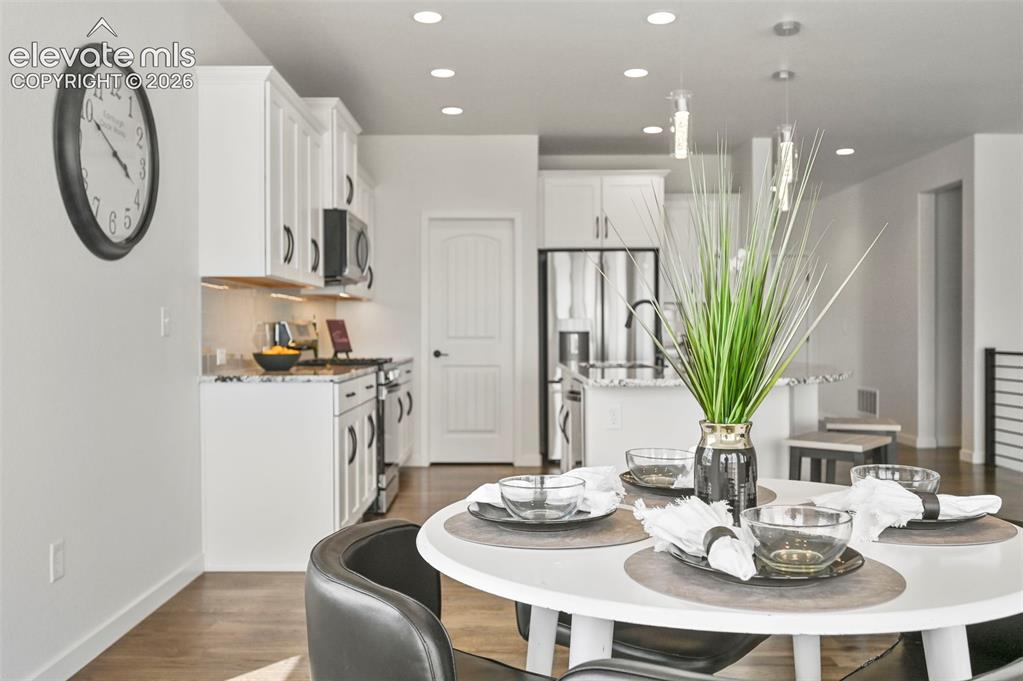 Image 11 of 38: Dining area with recessed lighting and dark wood-style flooring
