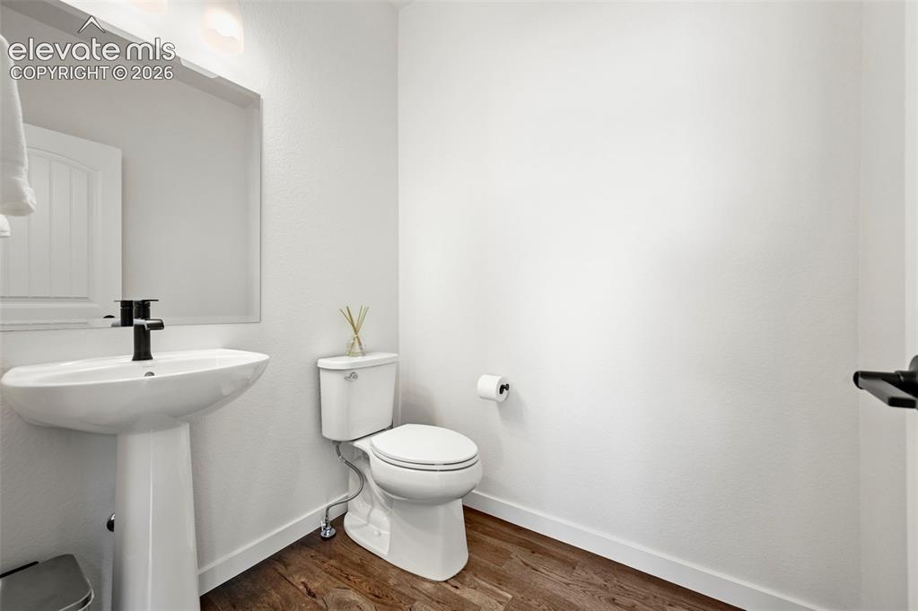 Image 17 of 38: Half bath with toilet and wood finished floors