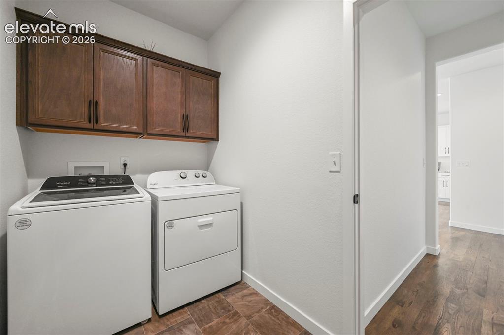 Image 19 of 38: Laundry room featuring independent washer and dryer, cabinet space, and dar