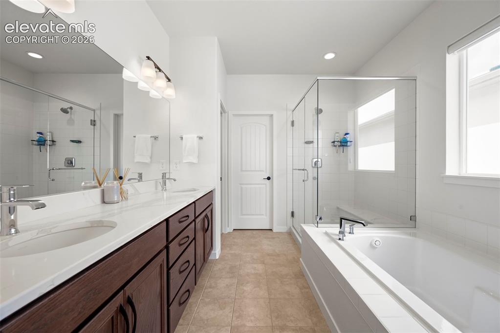 Image 23 of 38: Full bathroom featuring a stall shower, double vanity, a garden tub, recess