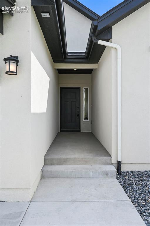 Image 6 of 38: Doorway to property with stucco siding