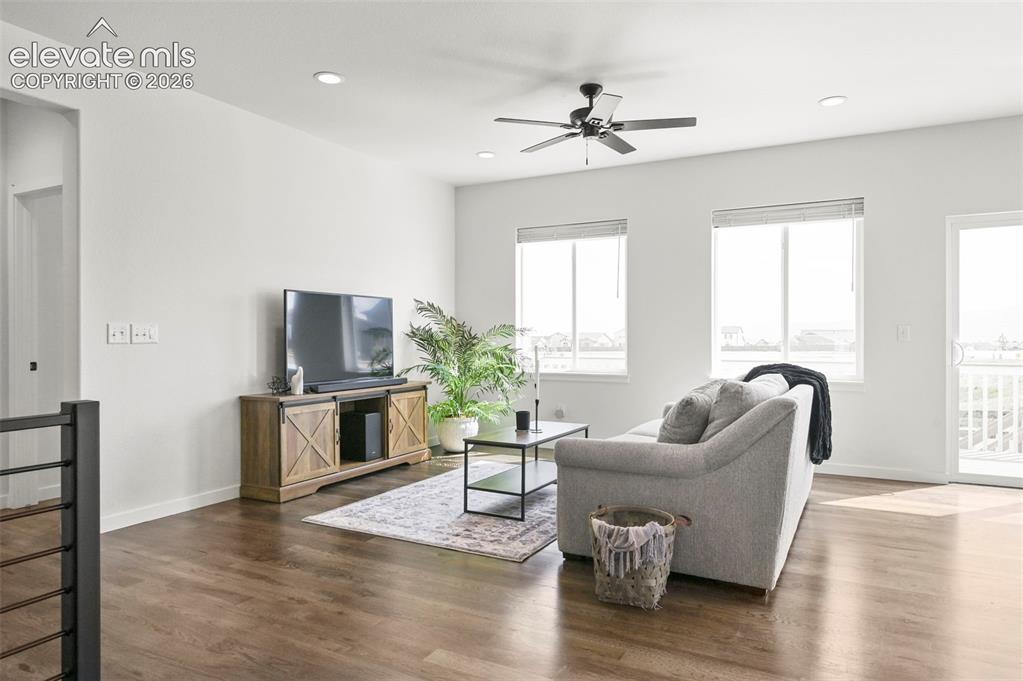 Image 8 of 38: Living area featuring a ceiling fan, dark wood finished floors, and recesse