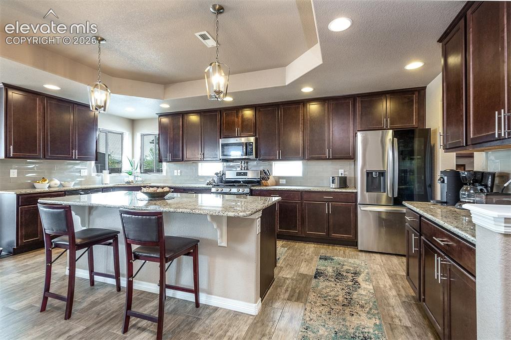 Image 10 of 45: The kitchen is a chef’s delight, featuring upgraded 42” cabinetry, granite 