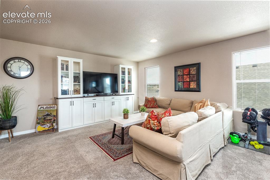 Image 20 of 45: Upstairs, you’ll find a generously sized family room with beautiful built-i
