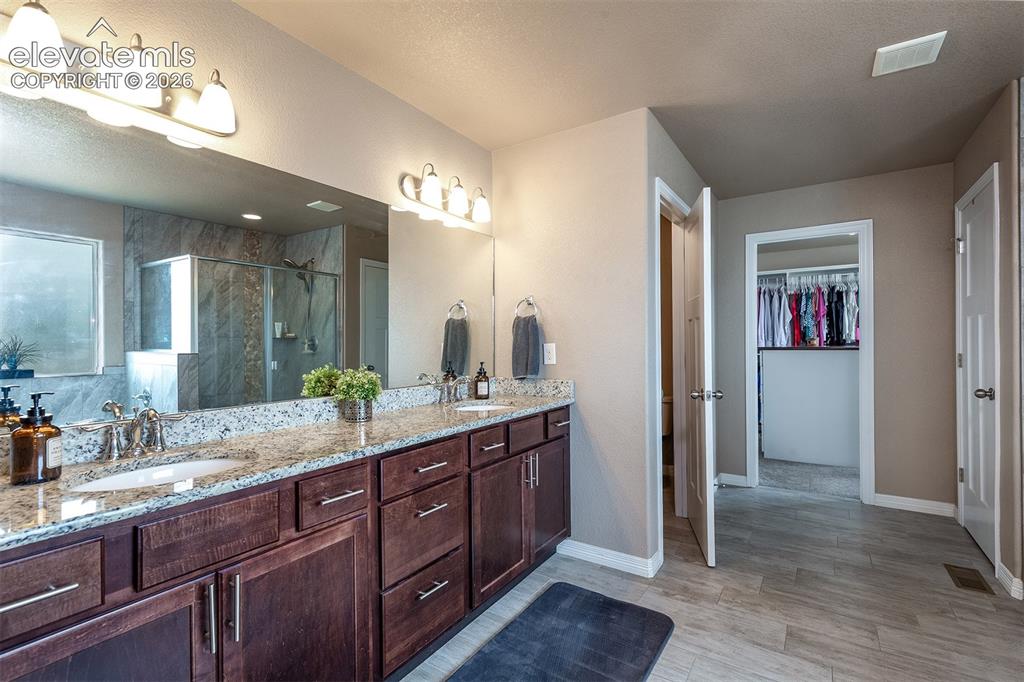 Image 26 of 45: Spacious primary 5-piece bath with an oversized double vanity, walk-in show