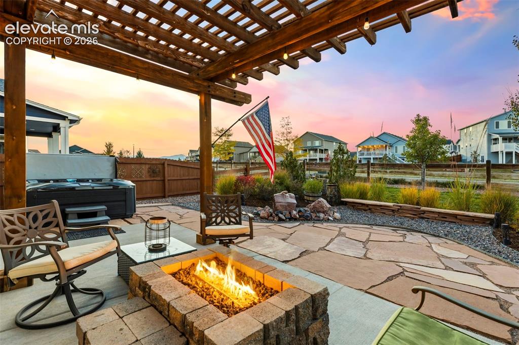 Image 35 of 45: Built-in firepit underneath the pergola