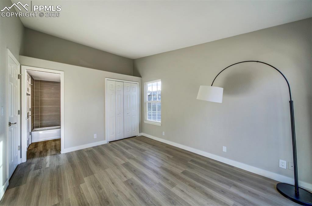 Image 16 of 33: Main level primary bedroom w/ large & deep closet and connected full bath