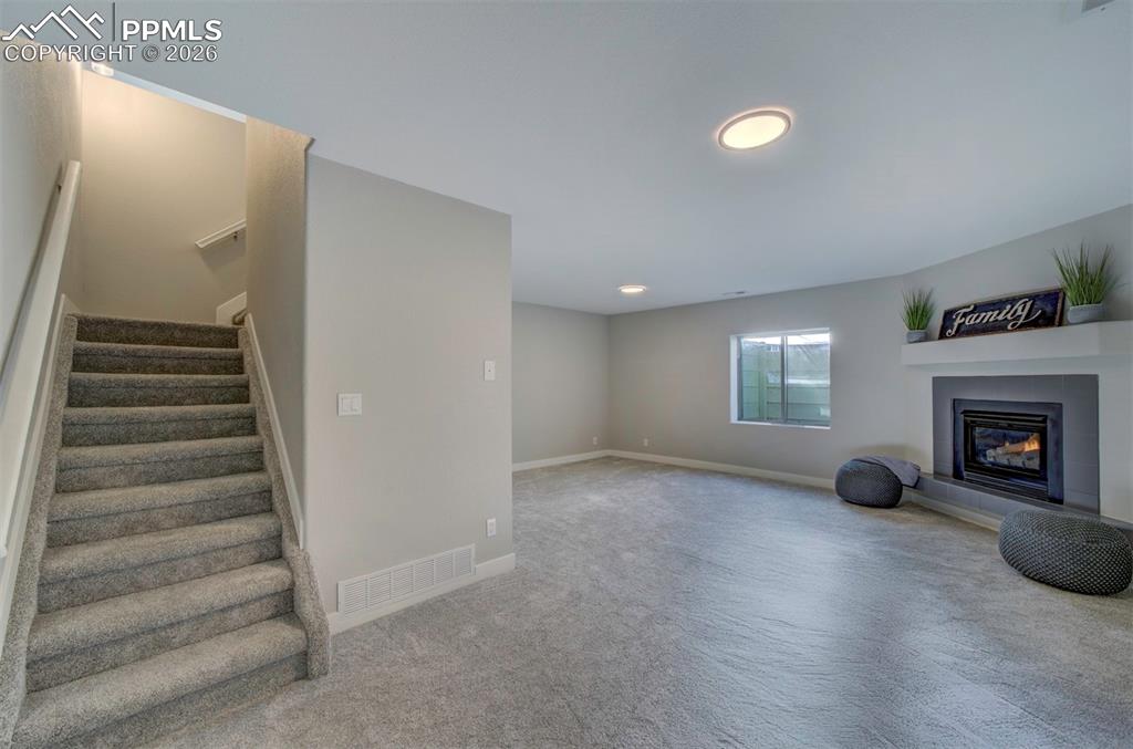 Image 23 of 33: Brand new carpet down here w/ an updated fireplace