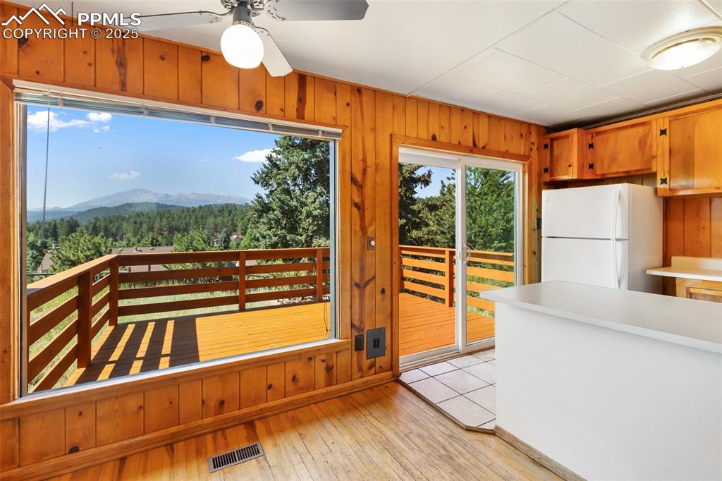 Image 11 of 35: Kitchen with freestanding refrigerator, a mountain view, wood walls, a ceil
