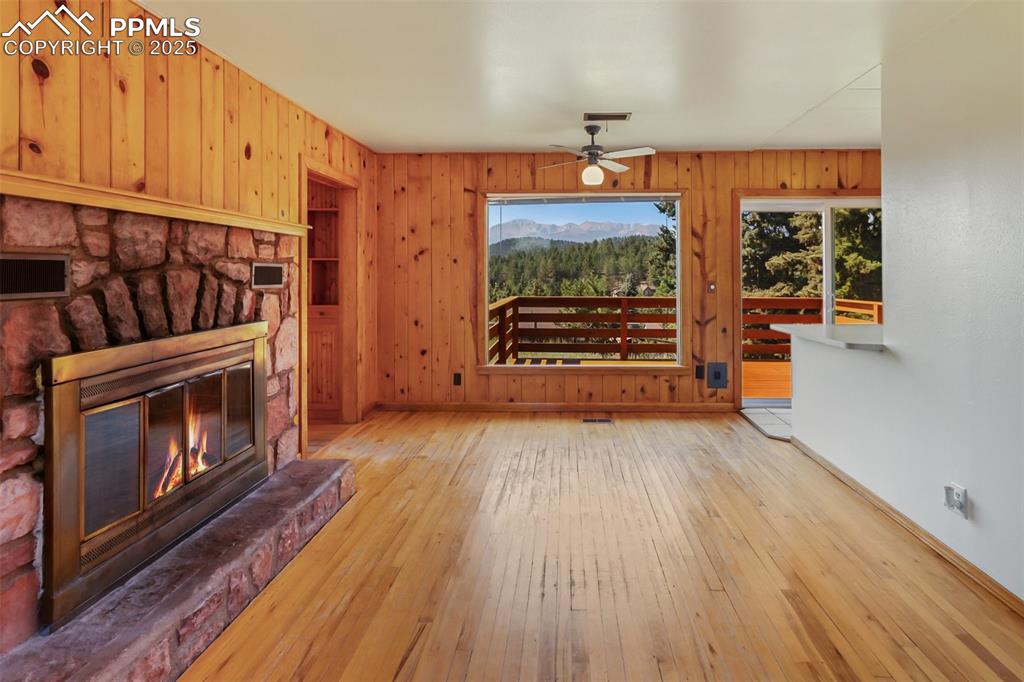 Image 13 of 35: Unfurnished living room with healthy amount of natural light, wood-type flo
