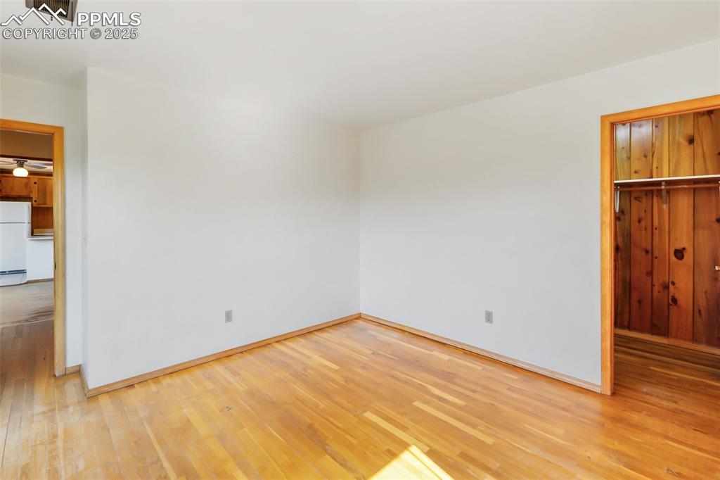 Image 21 of 35: Unfurnished bedroom featuring light wood-style flooring and freestanding re