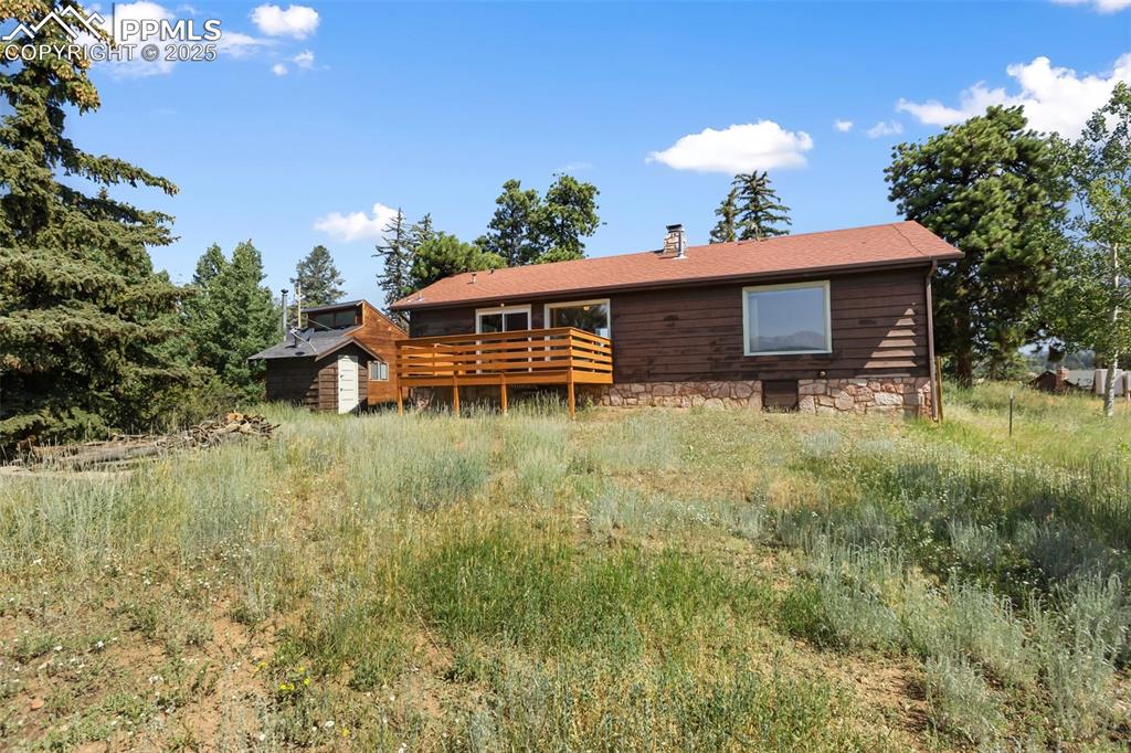 Image 5 of 35: Back of house with a chimney and a wooden deck