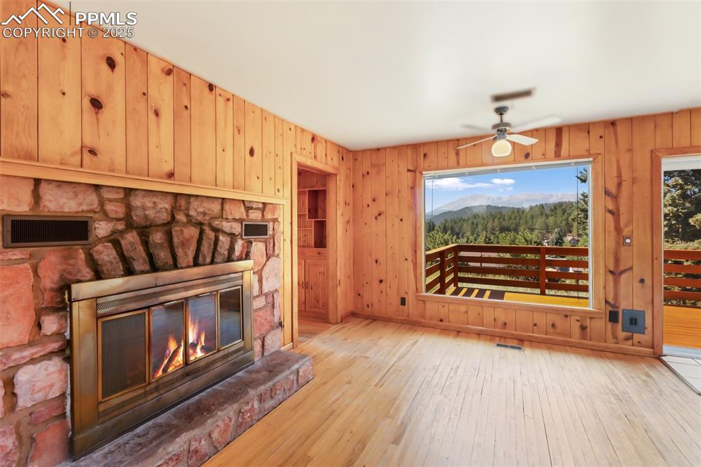 Image 8 of 35: Unfurnished living room featuring plenty of natural light, a fireplace, woo