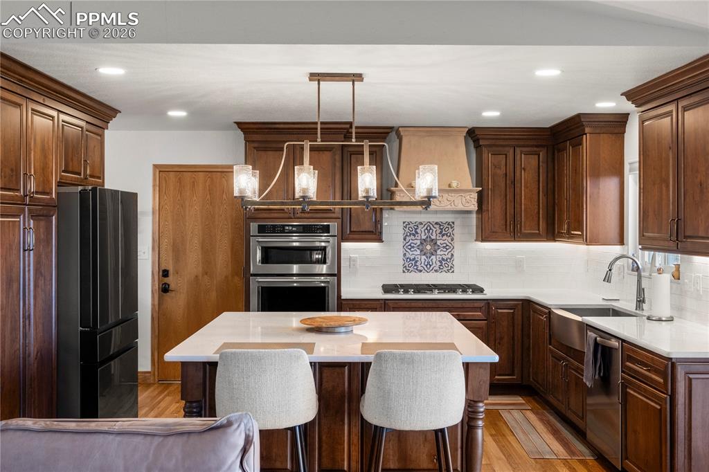 Image 10 of 46: Kitchen with gas range, large island, quartz countertops and tons of cabine