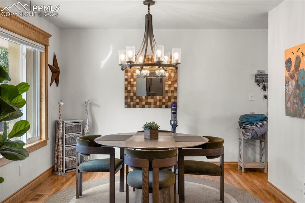 Image 17 of 46: Formal dining room, hardwood flooring and large picture window.