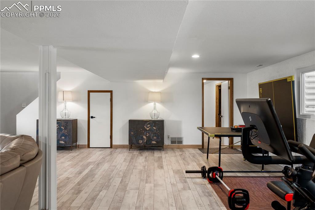 Image 26 of 46: Walkout basement with laminate flooring family room area and plenty of rec