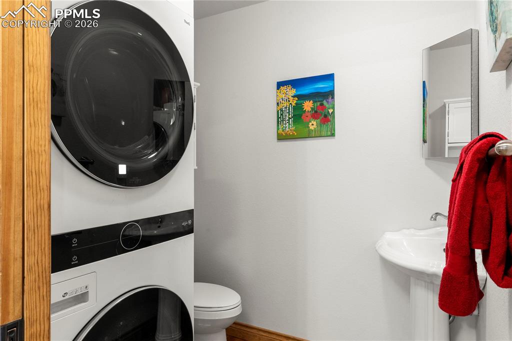 Image 6 of 46: Main level 1/2 bath with stackable washer and dryer.