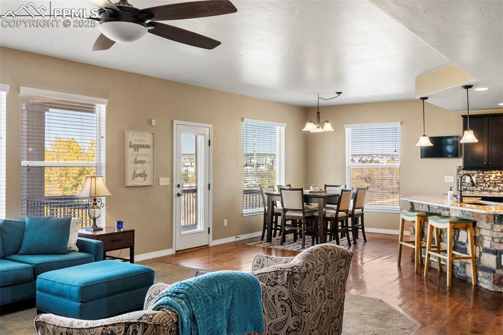 Image 11 of 41: Living area featuring wood finished floors, a ceiling fan, and a chandelier