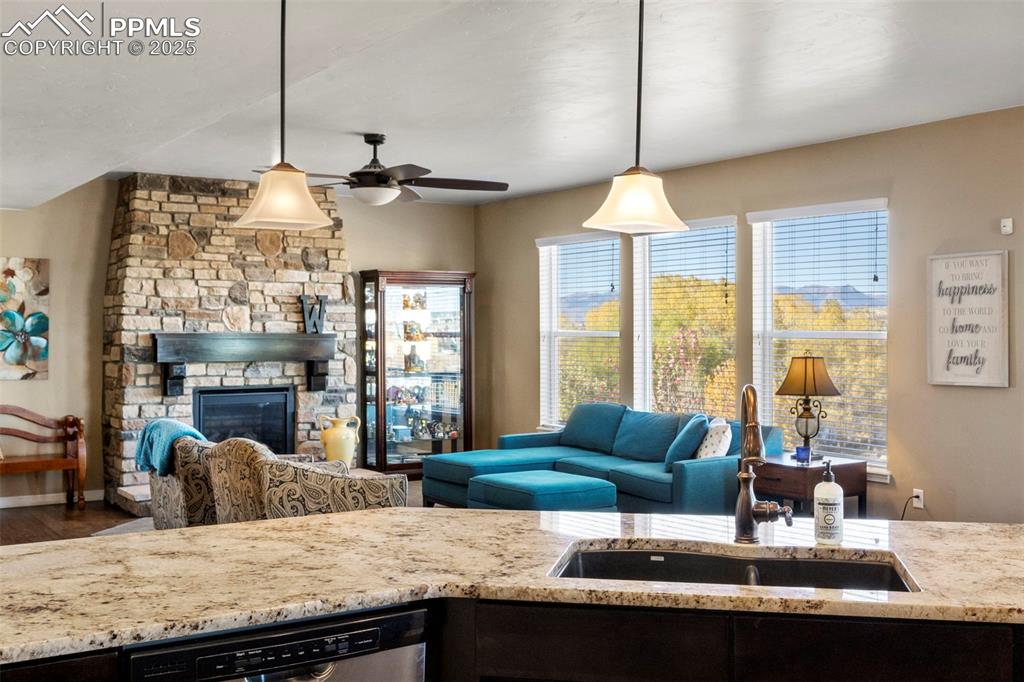 Image 16 of 41: Into living room featuring a fireplace and ceiling fan