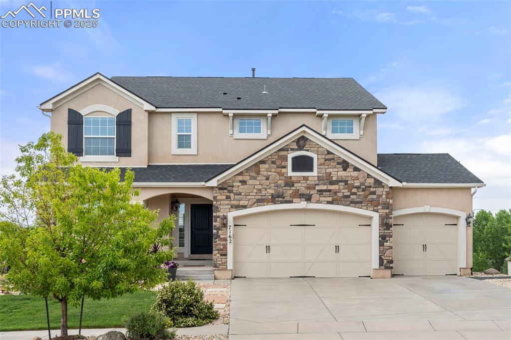 Image 2 of 41: View of front of home featuring stucco siding, roof with shingles, stone si