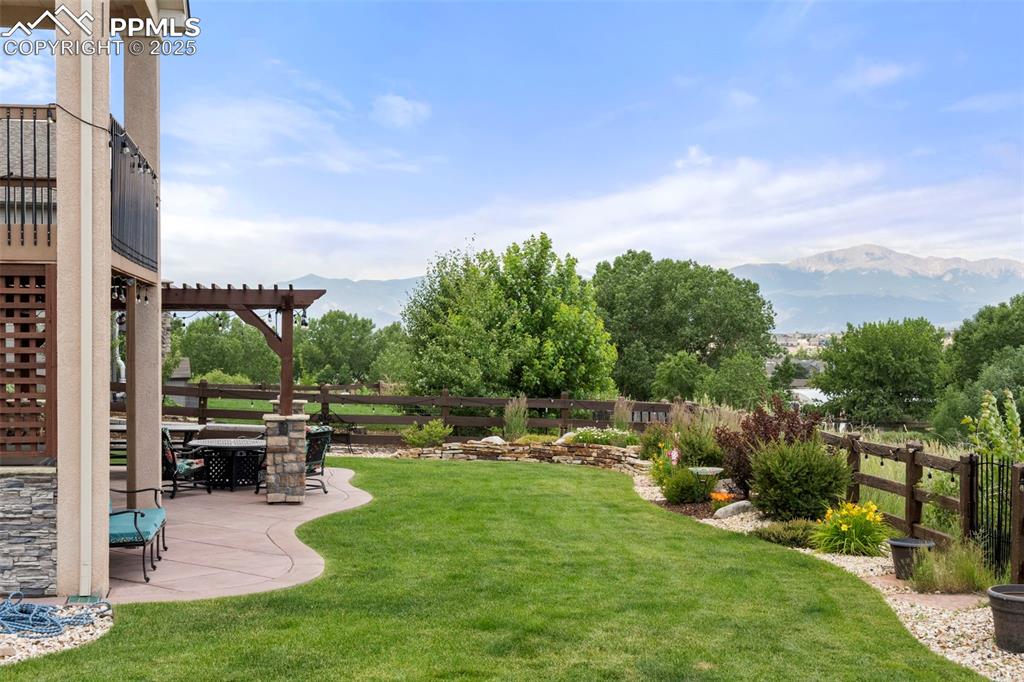 Image 3 of 41: Fenced backyard with a mountain view, a patio area, and a pergola