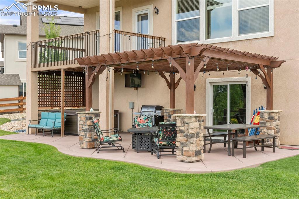 Image 4 of 41: Back of property with a pergola, stucco siding, a patio, and a yard